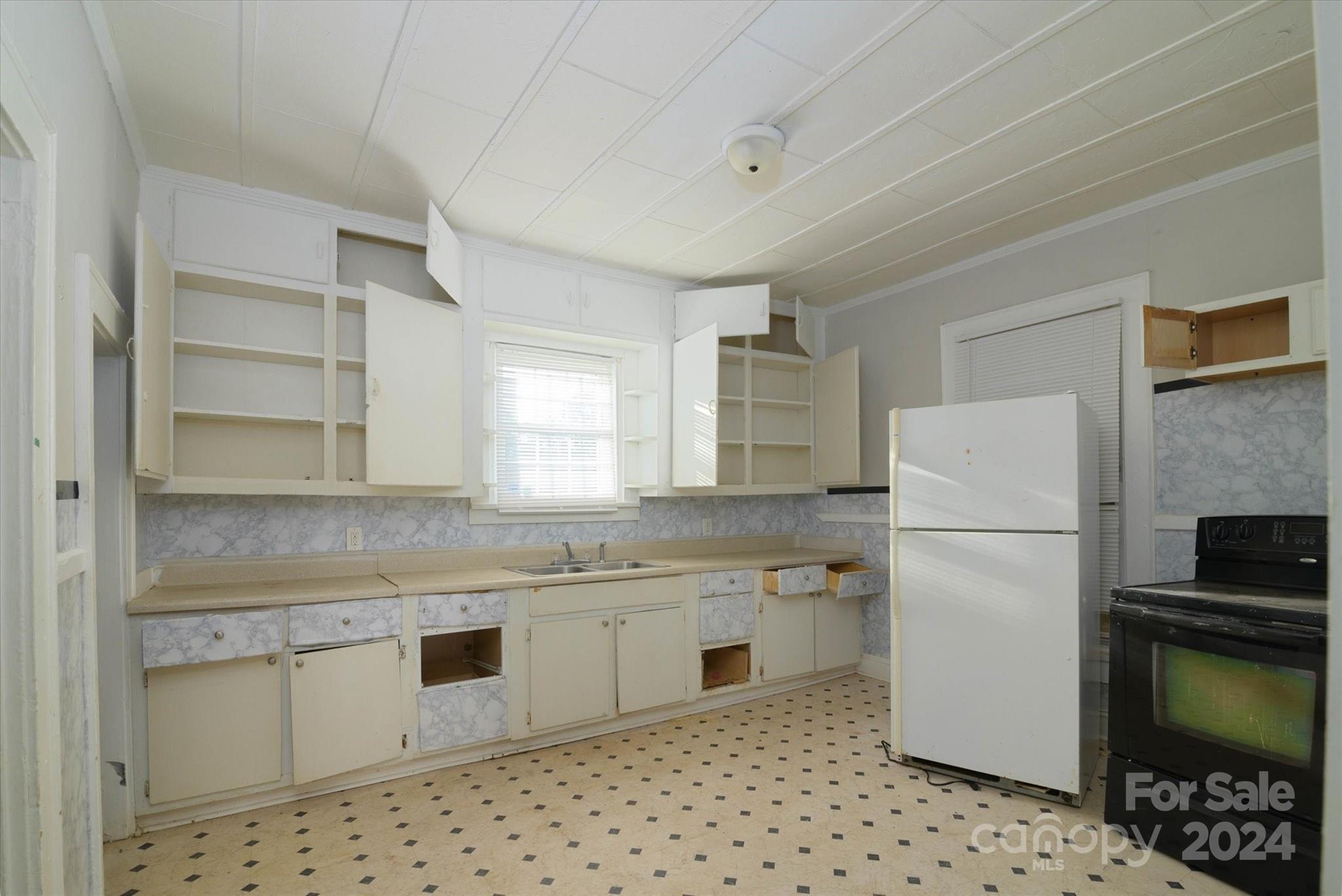 802 South Hoskins Road Charlotte, NC 28208 - Photo 11 of 15 a kitchen with a sink a stove a refrigerator and white cabinets