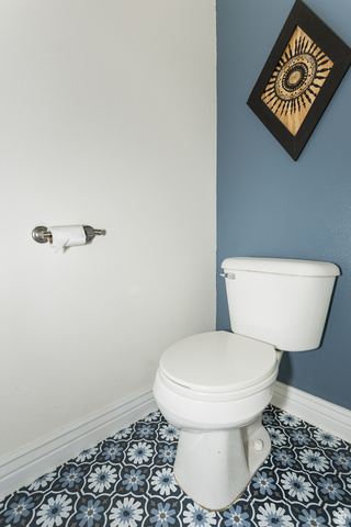 7797 North Windhover Road Eagle Mountain, UT 84005 - Photo 14 of 33 Powder room featuring a white toilet, patterned floor tiles in shades of blue and white, and a two-tone wall finish with white and blue paint