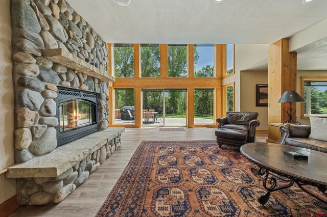 a living room with furniture large window and flat screen tv