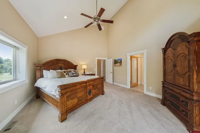 a bedroom with a bed next to a window with a chandelier