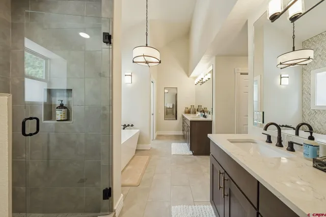 a spacious bathroom with a granite countertop sink a toilet a mirror and shower