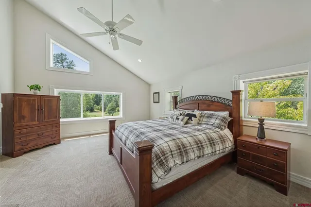 a bedroom with a bed a dresser and next to a window