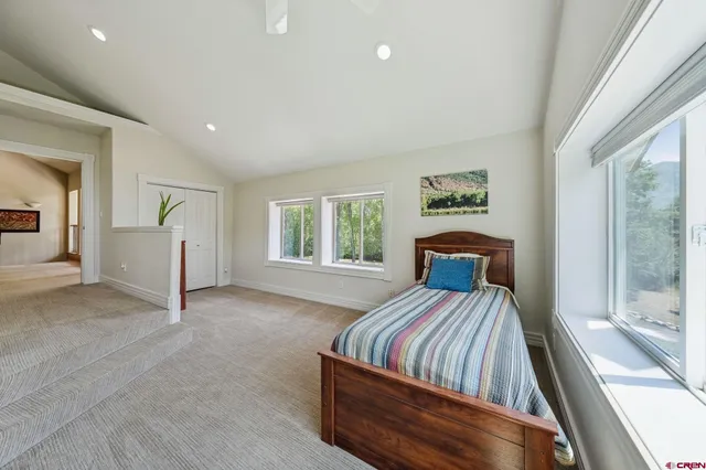 a bed sitting in a spacious bedroom next to a window