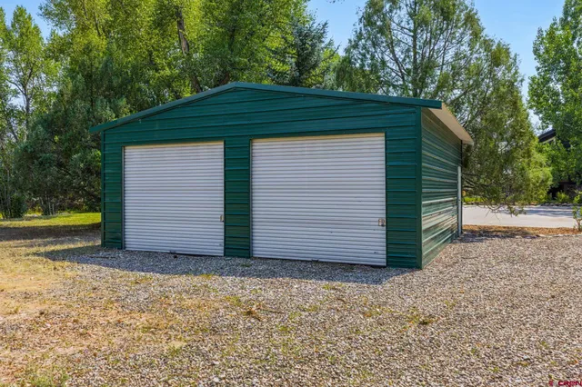 a house with a yard plants and large tree