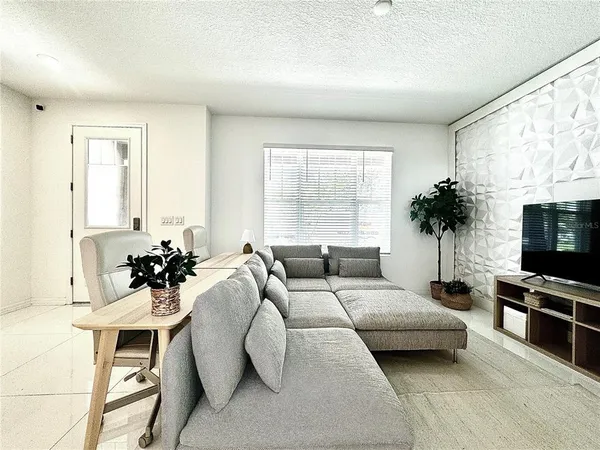 a living room with furniture a large window and a flat screen tv