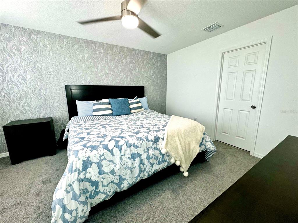10251 Highline Crest Street Orlando, FL 32832 - Photo 22 of 35 a bedroom with a bed and a night stand