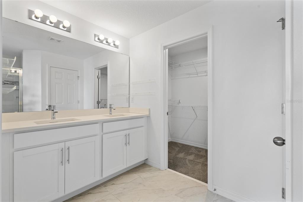 10251 Highline Crest Street Orlando, FL 32832 - Photo 24 of 35 a bathroom with a double vanity sink and mirror