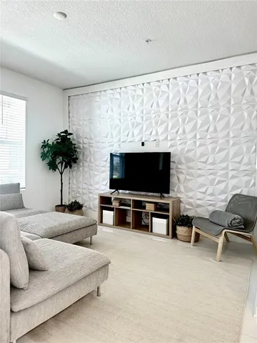 a view of a livingroom with furniture and a flat screen tv