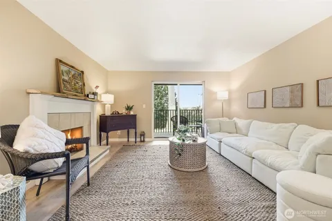 a living room with furniture a fireplace and a large window
