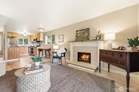 a living room with furniture a fireplace and a large mirror