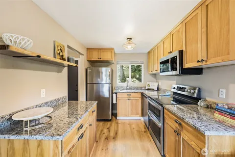 a kitchen with stainless steel appliances granite countertop a sink stove and refrigerator