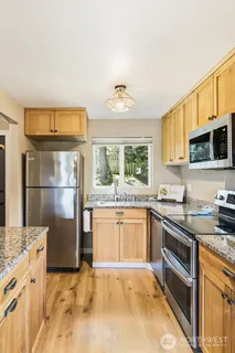 a kitchen with stainless steel appliances granite countertop a stove refrigerator sink and microwave