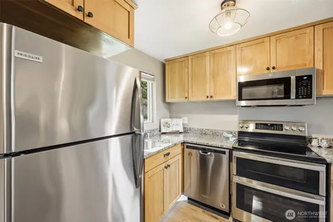a kitchen with stainless steel appliances a refrigerator sink and microwave