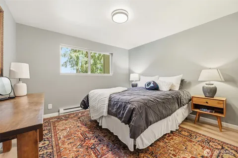 a bedroom with a bed and wooden floor