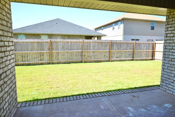 a view of a swimming pool with a lawn chairs and wooden fence