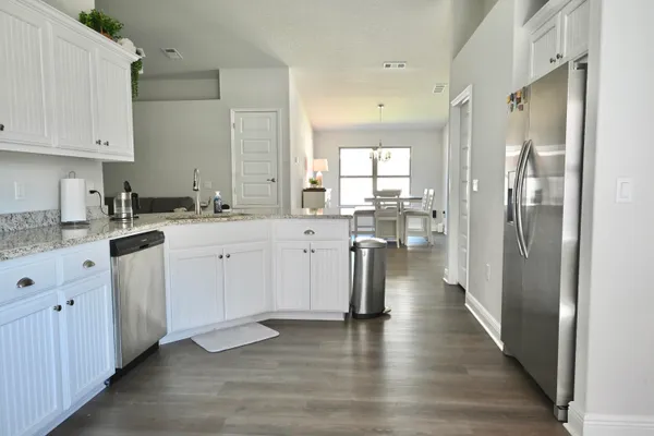 a kitchen with a sink cabinets and wooden floor