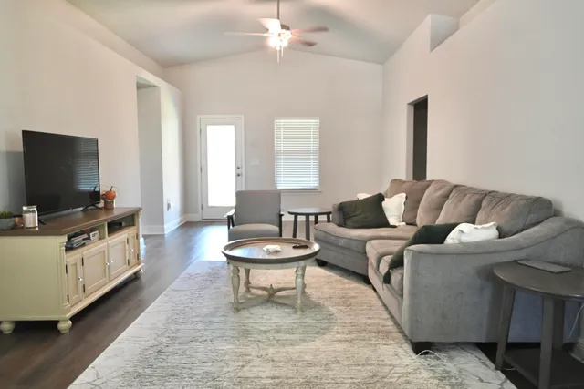 a living room with furniture and a wooden floor