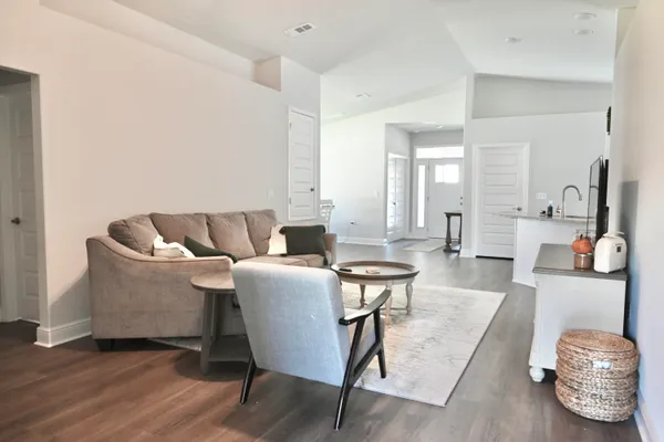 a living room with furniture and a wooden floor