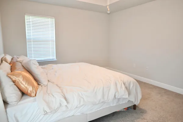 a large bed sitting in a bedroom next to a window