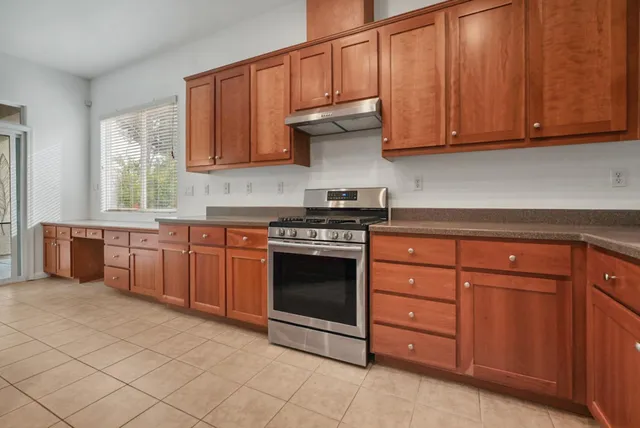 a kitchen with kitchen island granite countertop a sink counter and chairs