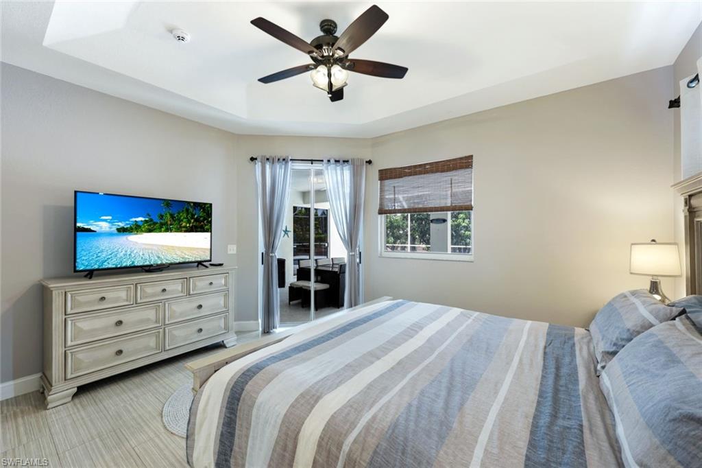 697 Crossfield Circle Naples, FL 34104 - Photo 12 of 18 Bedroom with a tray ceiling and ceiling fan