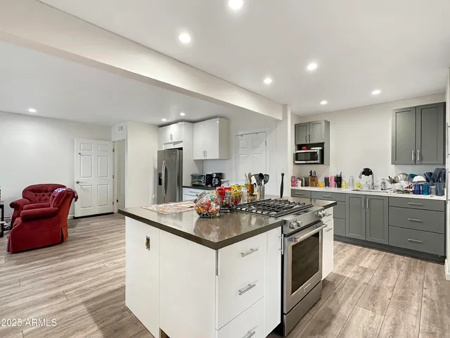 a kitchen with stainless steel appliances granite countertop a sink stove and refrigerator