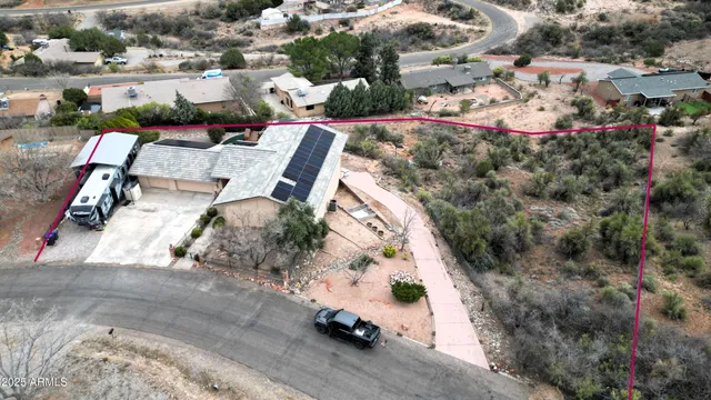 an aerial view of a house with a yard and parking spaces
