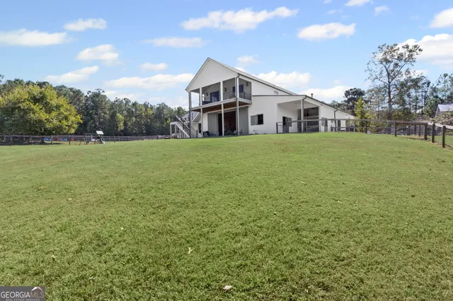 an aerial view of a house with a yard and lake view