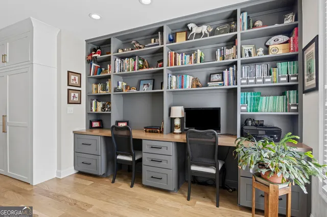 a dining room with wooden floor a chandelier a wooden table and chairs