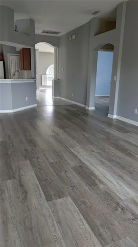 a view of empty room with wooden floor