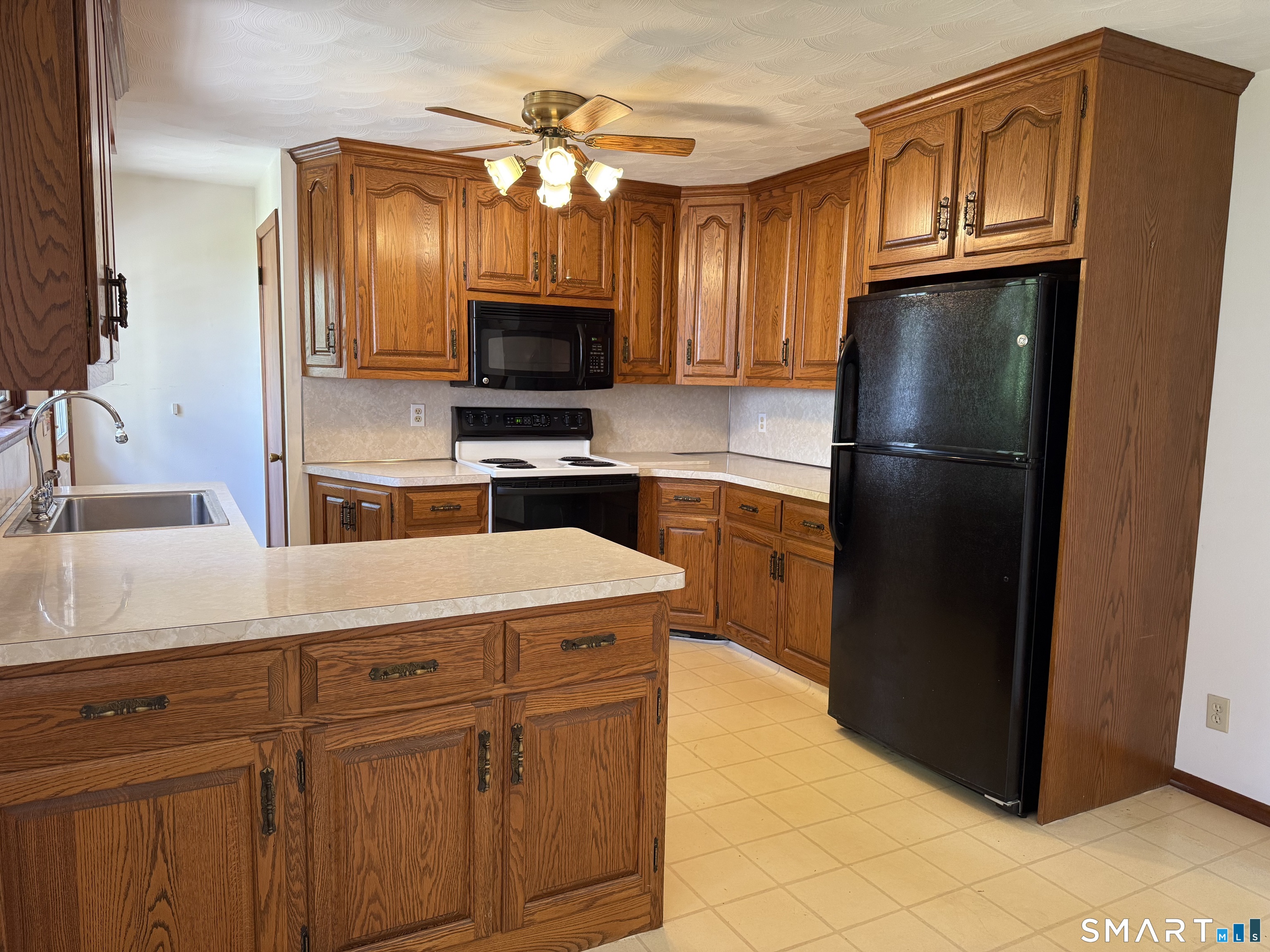 26 Maple Street Trumbull, CT 06611 - Photo 12 of 37 a kitchen with stainless steel appliances granite countertop a refrigerator oven a sink dishwasher and wooden cabinets
