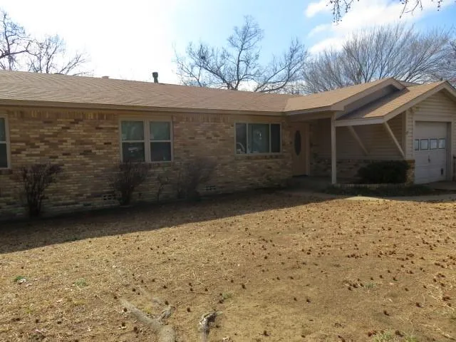 a view of house with backyard and trees