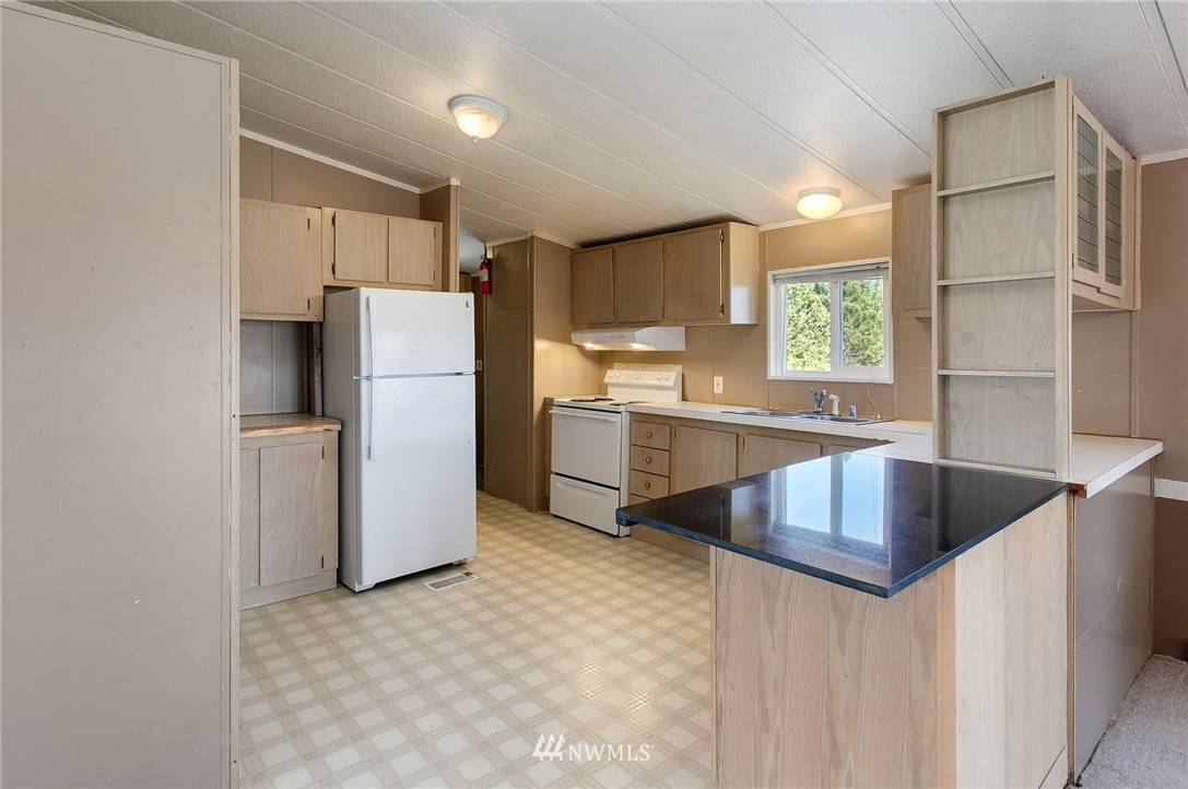 5998 Elder Road Ferndale, WA 98248 - Photo 5 of 23 a kitchen with refrigerator and cabinets