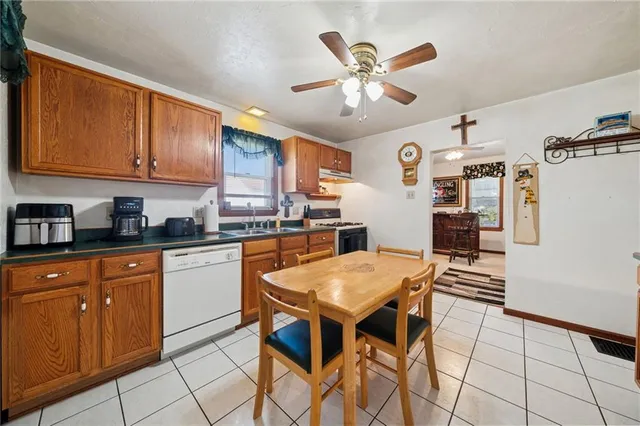 a kitchen with stainless steel appliances granite countertop a stove a sink dishwasher and a refrigerator with cabinets