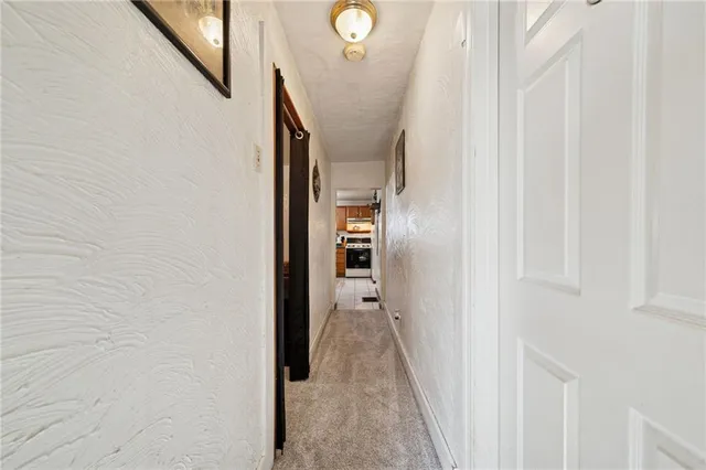 a view of a hallway with wooden floor and entryway