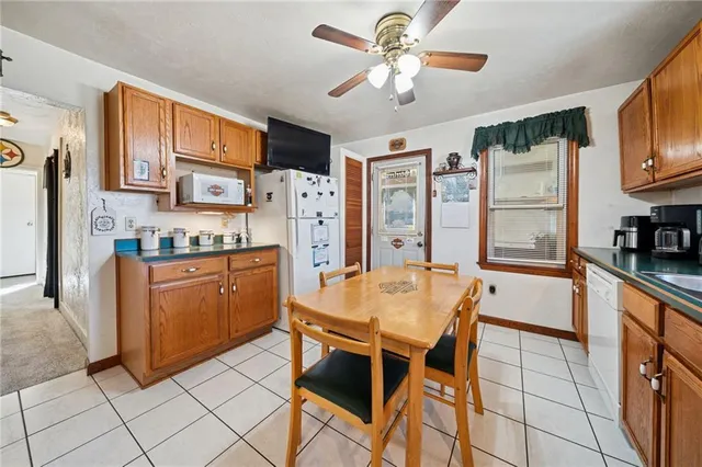 a kitchen with stainless steel appliances kitchen island granite countertop a refrigerator a stove a microwave oven with a dining table and chairs