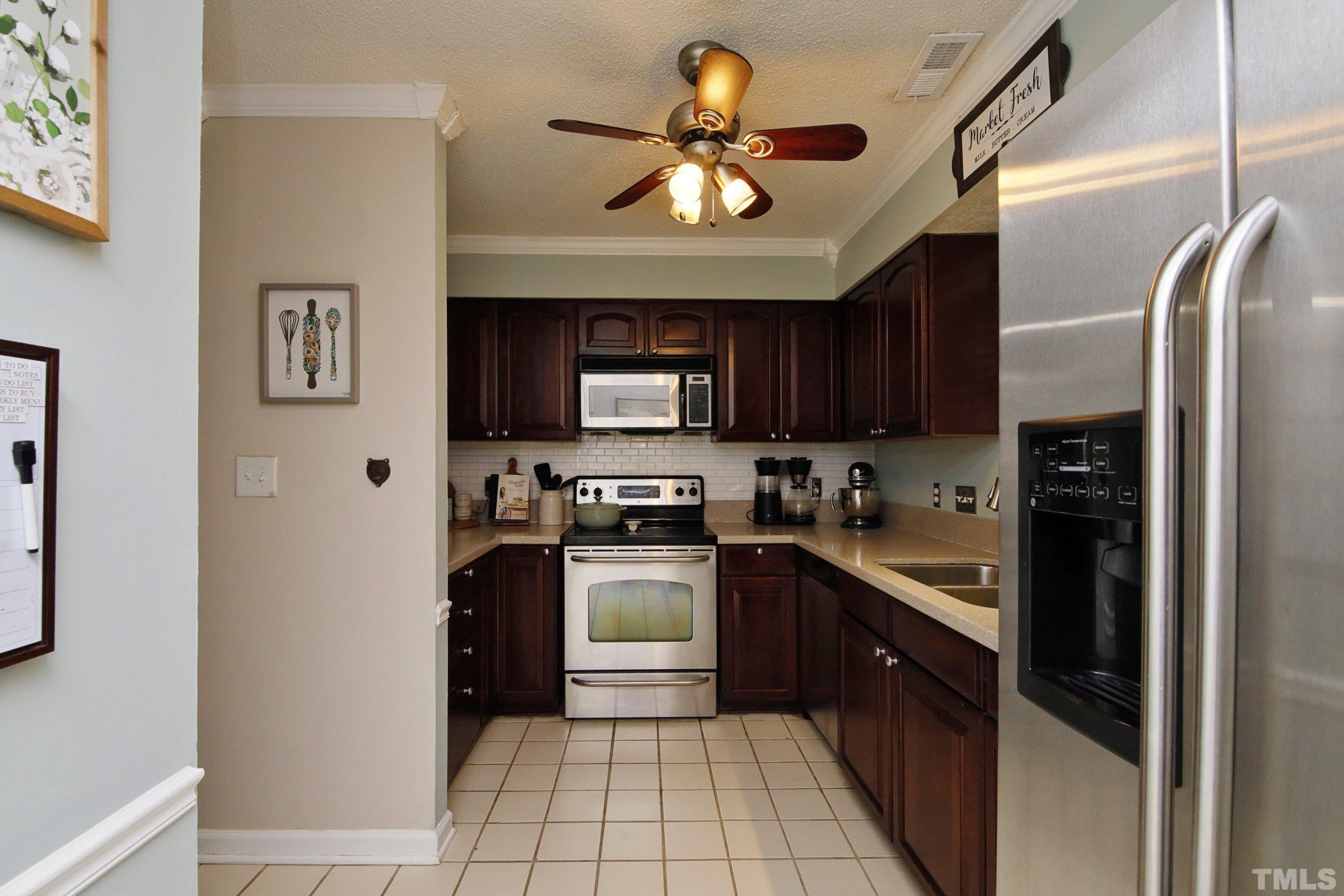 116 Long Shadow Place Durham, NC 27713 - Photo 7 of 38 a kitchen with stainless steel appliances granite countertop a refrigerator a stove top oven a sink and dishwasher