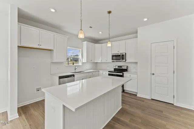 a kitchen with granite countertop a sink a counter space stainless steel appliances and cabinets