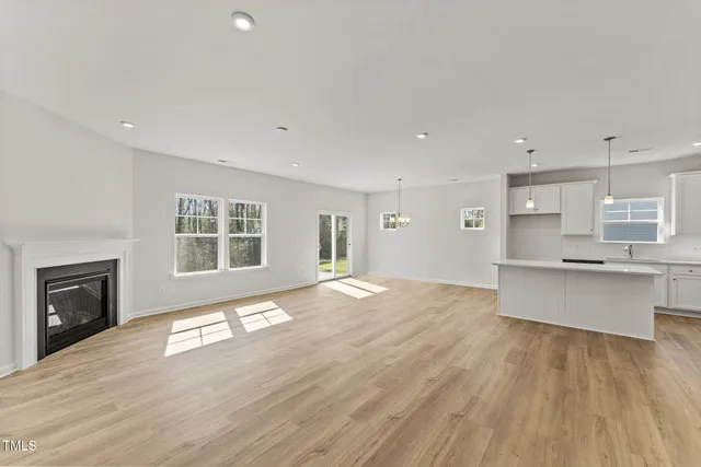 a large empty room with a fireplace and wooden floor