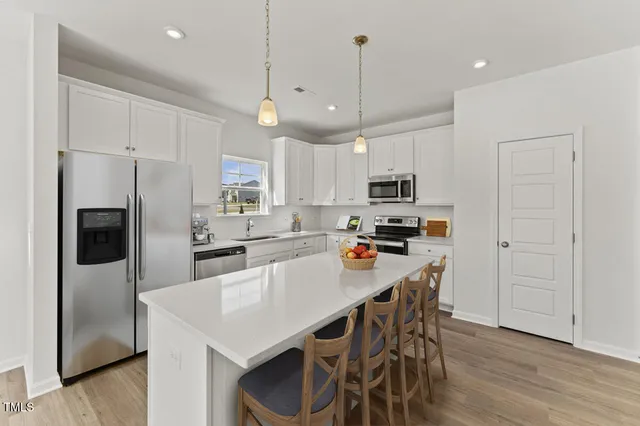 a kitchen with stainless steel appliances a refrigerator a stove a sink and a microwave