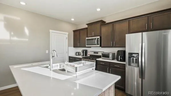 a kitchen with granite countertop a sink stove and refrigerator