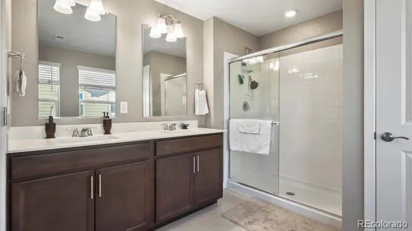 a bathroom with a double vanity sink mirror and shower