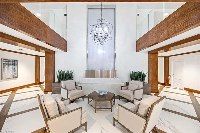 a living room with furniture chandelier and a table