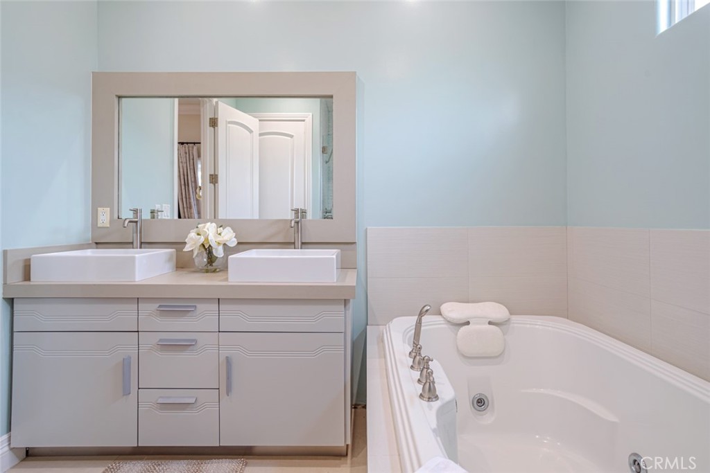 12945 Calvert Street Van Nuys, CA 91401 - Photo 40 of 57 a bathroom with a sink a vanity and mirror