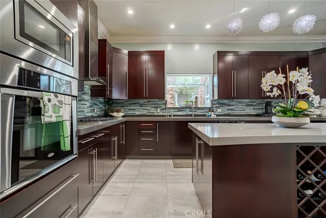 a kitchen with kitchen island granite countertop a sink counter top space cabinets and stainless steel appliances