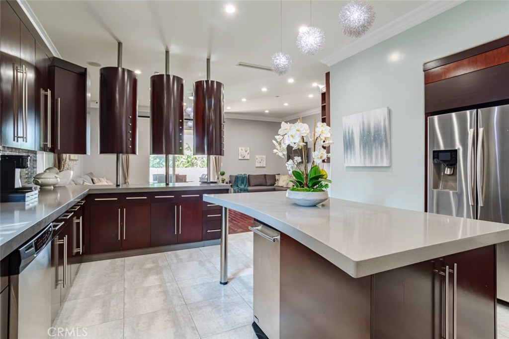 12945 Calvert Street Van Nuys, CA 91401 - Photo 10 of 57 a kitchen with a refrigerator a sink and wooden cabinets