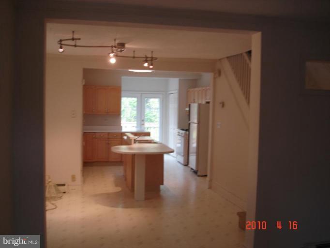 420 Walcott Road Baltimore, MD 21206 - Photo 4 of 11 a view of a hallway with wooden floor and a bathroom