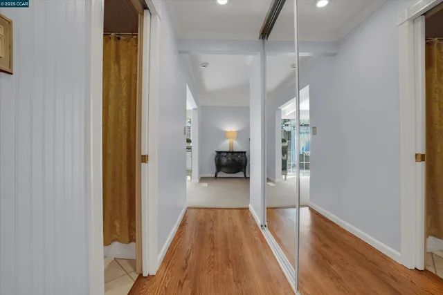 a view of a hallway with wooden floor and staircase