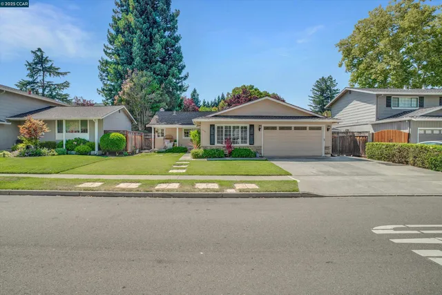 a view of house with a big yard and potted plants