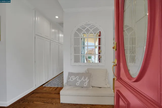 wooden floor with a mirror next to a window